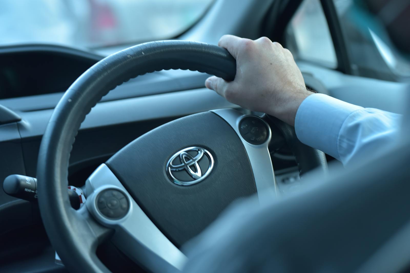 Photo by ALEEM UL HASSAN Close-up view of a hand gripping a Toyota steering wheel in a car interior, Faisalabad, Pakistan.